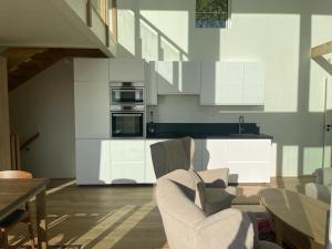 a kitchen with white cabinets and chairs in a room at Seaside panorama Villa with JETLESS hot tub in Gothenburg