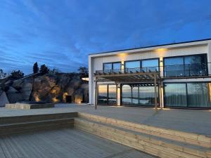 a large house with a deck with a mountain at Seaside panorama Villa with JETLESS hot tub in Gothenburg