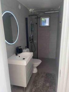 a bathroom with a sink and a toilet and a mirror at Seaside panorama Villa with JETLESS hot tub in Gothenburg +45 photos