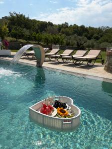 a pool with a bowl of fruit in the water at Villa Kroi i Vashes in Peqin