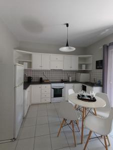 a kitchen with a table and chairs and a white refrigerator at Nini's House Superior Nydri - 100m from beach NYDRI TOWN CENTER in Nydri