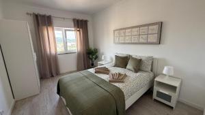 a white bedroom with a bed and a window at Bela House, By Home Match in Setúbal