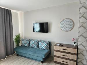 a living room with a couch and a tv on the wall at къща Чипровка in Chiprovtsi