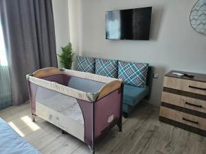 a baby crib in a bedroom with a couch at къща Чипровка in Chiprovtsi +17 photos