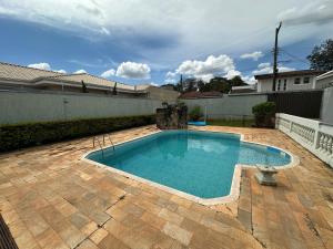 a swimming pool in the backyard of a house at Aconchego do Lago in Espirito Santo Do Pinhal +5 photos
