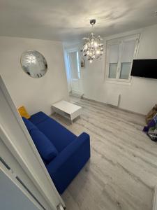 a living room with a blue couch and a chandelier at Sam's cocoon in Vicq-sur-Nahon