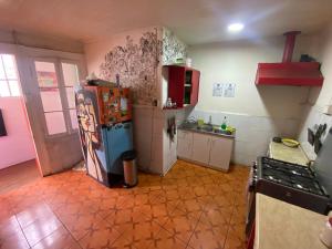 a kitchen with a refrigerator and a stove at La Mancha Art Hostel - Cerro Alegre - Valparaiso in Valparaíso
