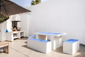 a white table and two benches on a patio at Villa Amare in Benissa