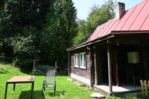 a house with a chair and a table in front of it at Chata Naděje in Kořenov