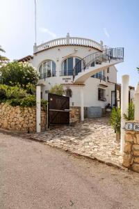 a white house with a gate in front of it at Villa Amare in Benissa