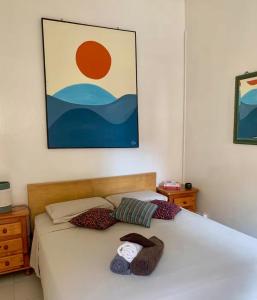 a bedroom with two beds and a painting on the wall at Malika Surf House in Dakar