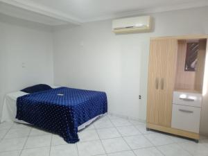 a room with a blue table and a cabinet at Pousada Exclusiva in Rondonópolis