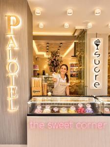 a woman standing behind the counter of a bakery at Palotel Gouvia Hotel in Gouvia +42 photos
