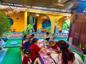 a group of people sitting at a table eating at Twin Double Room in Phú Ngọc (1)