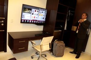 a man standing in front of a desk with a computer at Business Class Prims Hotel in Jaén