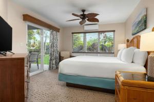 a bedroom with a bed and a tv and a window at Club Wyndham Bali Hai Villas in Princeville