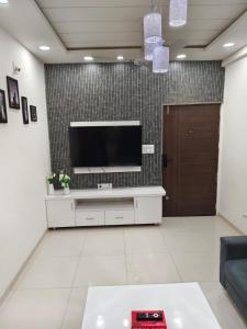 a living room with a flat screen tv on a wall at 2bhk penthouse with open tarace in Vadodara
