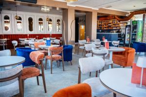 a dining room with tables and chairs and a bar at Garni Hotel Maggitti in Velika Plana