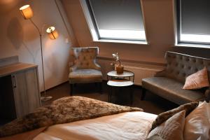 a bedroom with a bed and a couch and a chair at Hotel De Vrouwe van Stavoren in Stavoren