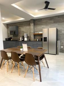 a kitchen with a table and chairs and a refrigerator at The Ansen Place in Belmopan