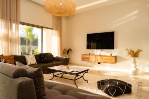 a living room with a couch and a tv at Luxurious Marrakech Villa Pool, Hammam,Cinema in Marrakesh