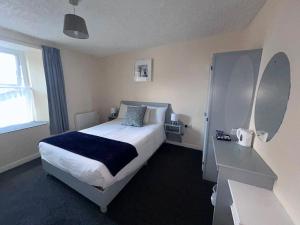 a bedroom with a large bed and a desk at O'Loughlin's Bar in Milltown Malbay +15 photos
