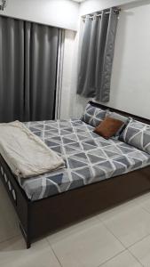 a bed in a bedroom with a black bed frame at 2bhk penthouse with open tarace in Vadodara