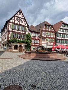 a group of buildings with a fountain in a courtyard at Gästehaus am Marktbrunnen in Bretten