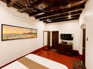 a room with a bed and a tv on a wall at Udupi River Inn in Kalyānpur