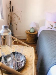 a tray with glasses on a table next to a bed at la colombe du marais in Courçon