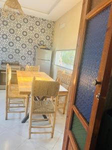 a dining room with a wooden table and chairs at Sisi villa in Essaouira