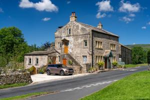 a car parked in front of a stone house at The Dale - Luxurious annexe with stunning view in Buckden