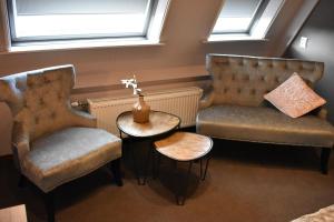a waiting room with two chairs and a table and a vase at Hotel De Vrouwe van Stavoren in Stavoren