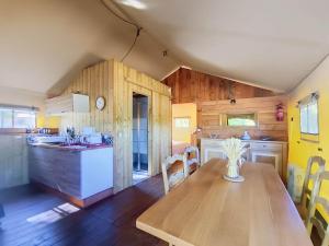 a kitchen and dining room with a wooden table at Lodge La Belle Vie in Vigeois