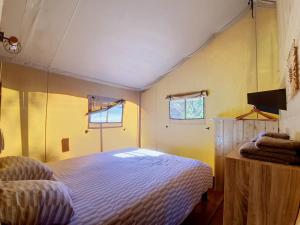 a bedroom with a bed and two windows at Lodge La Belle Vie in Vigeois