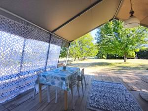 a table and chairs sitting under a tent on a patio at Lodge La Belle Vie in Vigeois