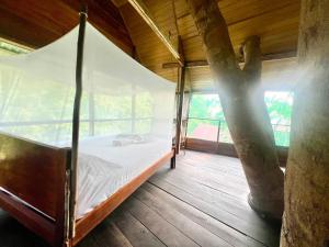 a bed in a room with a tree at Reserva Natural Natura Park in Loreto Mocagua