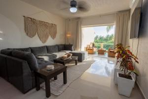 a living room with a couch and a table at Stunning Large Remodeled Penthouse-Big Canal Views in Puerto Aventuras