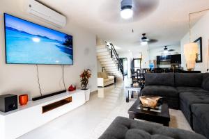 a living room with a large screen tv on a wall at Stunning Large Remodeled Penthouse-Big Canal Views in Puerto Aventuras