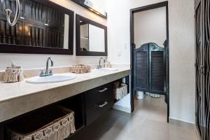 a bathroom with two sinks and a large mirror at Stunning Large Remodeled Penthouse-Big Canal Views in Puerto Aventuras