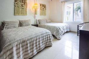 a bedroom with two beds and a window at Stunning Large Remodeled Penthouse-Big Canal Views in Puerto Aventuras