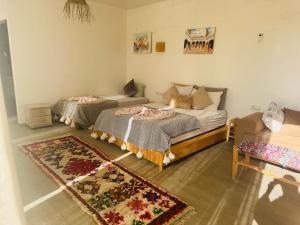 a bedroom with two beds and a rug at Sisi villa in Essaouira +25 photos