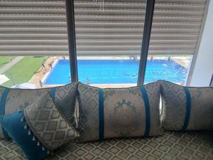 a couch in front of a window with a view of a pool at Puerto banus beach Apt Famillies and married couples in Mansouria