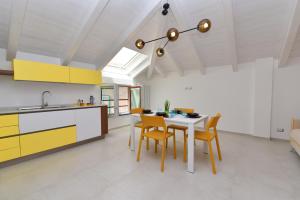 a kitchen with yellow and white cabinets and a table and chairs at SoleLuna Agerola in Agerola +32 photos