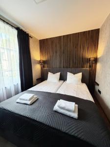 a bedroom with a bed with two towels on it at Edel Wellness Sleep & Spa in Gniezno
