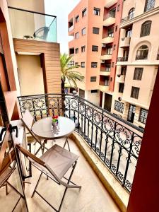 a balcony with a table and chairs on a balcony at Oasis Gueliz Center Marrakech in Marrakesh