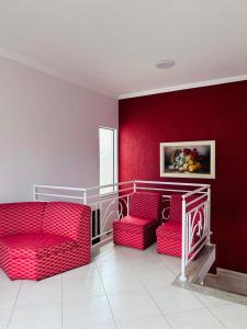 a room with two red chairs and a red wall at Pousada São Nicolau in Cachoeira Paulista