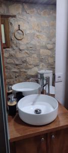a bathroom with a sink and a stone wall at Habitació doble Àger in Àger