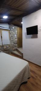 a room with a bed and a stone wall at Habitació doble Àger in Àger