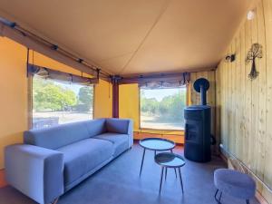 a living room with a blue couch and two tables at Lodge La Vie Douce in Vigeois